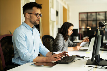 Businessman in office. Handsome man talking on phone at work..