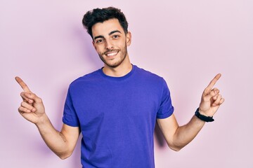Fototapeta premium Young hispanic man wearing casual t shirt smiling confident pointing with fingers to different directions. copy space for advertisement