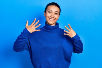 Beautiful hispanic woman with short hair wearing turtleneck sweater showing and pointing up with...