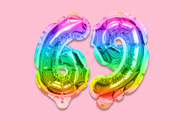 Rainbow foil balloon number, digit sixty nine on a pink background. Birthday greeting card with inscription 69. Top view. Numerical digit. Celebration event, template.