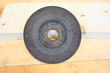 grinding wheel lying on wooden bench in workshop