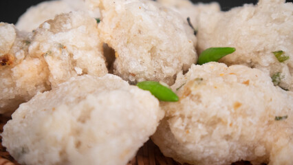 extreme close up a bowl of fried tapioka flour in a black background