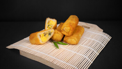 sliced Indonesian Rissoles on a black background