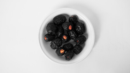 a plate of ajwa dates in a white background