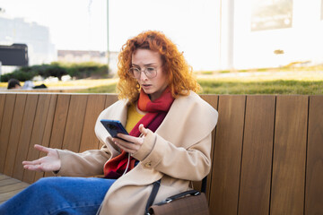 A woman expressing distress after reading bad news on her smartphone