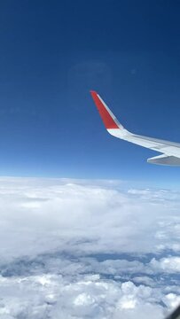 Airplane flight. Wing of aircraft above clouds with blue sky. View from window of plane. Feeling of freedom. Traveling on fastest and safest means of transport.