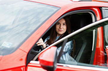 Fototapeta na wymiar Gorgeous woman sitting inside car with open door.
