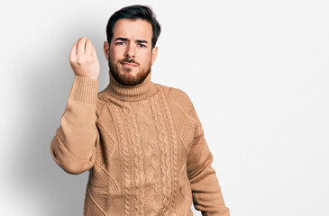 Young hispanic man wearing casual clothes doing italian gesture with hand and fingers confident expression