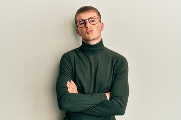 Young caucasian man wearing glasses with arms crossed gesture looking at the camera blowing a kiss being lovely and sexy. love expression.