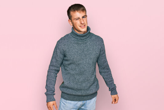 Young blond man wearing casual clothes winking looking at the camera with sexy expression, cheerful and happy face.