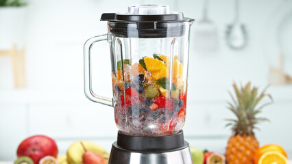 Mixing pieces of fruits and in blender. Preparation of healthy drink.