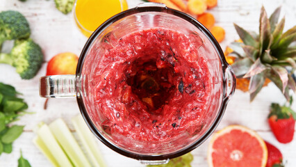 Mixing pieces of fruits in blender, top view.