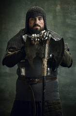 Vintage portrait of brutal seriuos man, medieval warrior or knight with wounded face in chain mail...