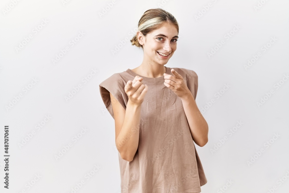 Sticker young blonde woman standing over isolated background pointing fingers to camera with happy and funny