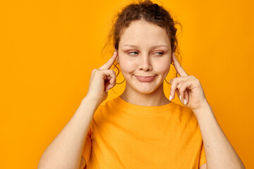 portrait of a young woman fun earrings grimace hand gesture Youth style yellow background unaltered