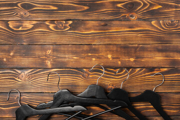 Composition with clothes hangers on wooden background.