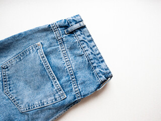 Blue jeans close-up on a white background. Belt and jeans pockets