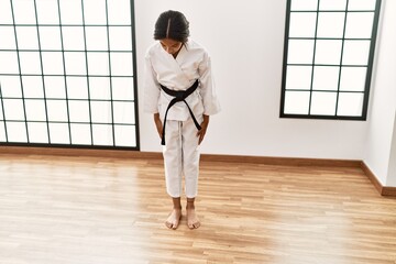 African american girl wearing kimono training karate at sport center
