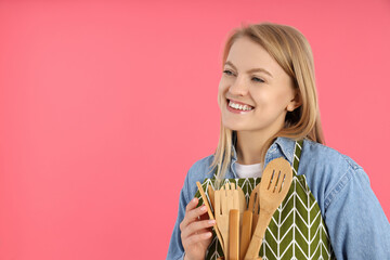 Young housewife woman in apron on pink background