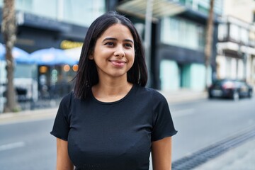 Young latin woman smiling confident standing at street