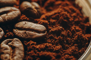 Roasted coffee beans lie in ground coffee.