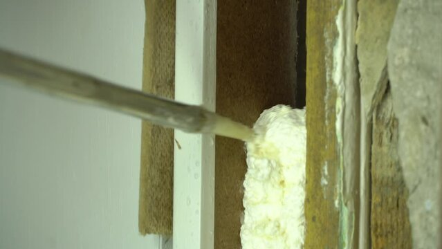 Use construction foam. The master with the help of mounting foam, repairs the door jamb. The master uses construction foam. The installer fills the door slope with foam. Polyurethane.