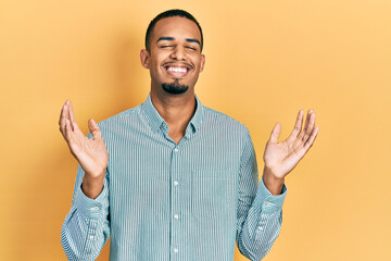 Young african american man wearing casual clothes celebrating mad and crazy for success with arms...