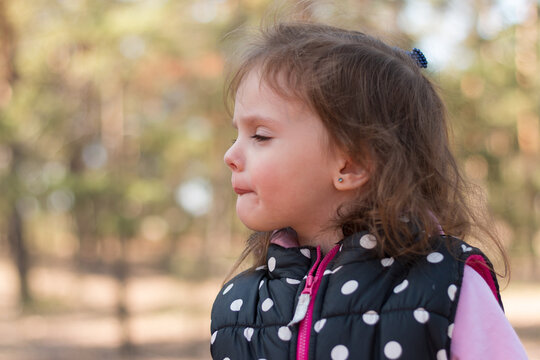 Beautiful Little Girl In A Polka Dot Vest On A Walk In The Forest