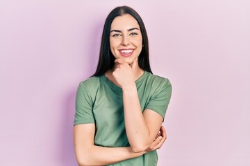 Obraz premium Beautiful woman with blue eyes wearing casual t shirt looking confident at the camera smiling with crossed arms and hand raised on chin. thinking positive.