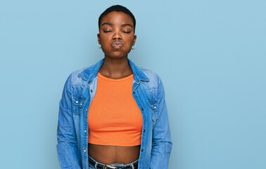 Young african american woman wearing casual clothes puffing cheeks with funny face. mouth inflated...