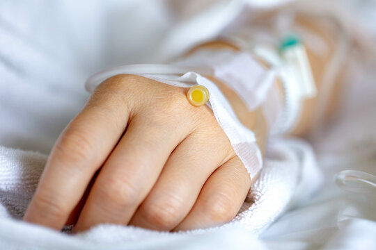 Woman's hand piercing needle to give saline solution
