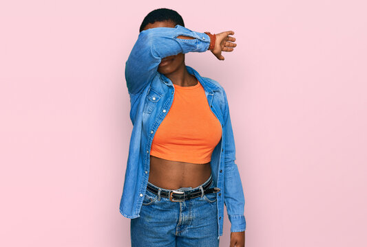 Young african american woman wearing casual clothes covering eyes with arm, looking serious and sad. sightless, hiding and rejection concept