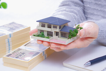 住宅とお金とシニア女性の手元