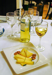 Plato de queso con acompañado de vino blanco