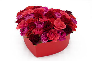 Heart of colorful red roses in a box on white background