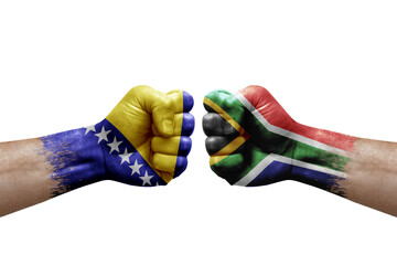 Two hands punch to each others on white background. Country flags painted fists, conflict crisis concept between bosnia and south africa