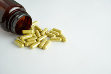 vitamins in yellow capsules for eyes - lutein on a white background with a brown bottle