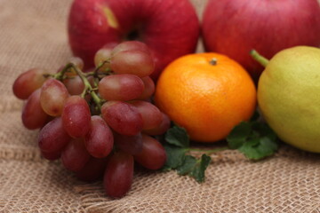 Fruits with vitamin C that are beneficial to the body. Place on sackcloth - orange, grape, apple, guava