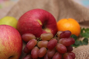 Fruits with vitamin C that are beneficial to the body. Place on sackcloth - orange, grape, apple, guava