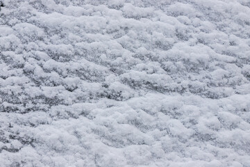 Beautiful winter background with snowy ground. Natural snow texture. Wind sculpted patterns on snow surface
