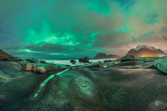 Scenic landscape of aurora over rocky seashore in Norway