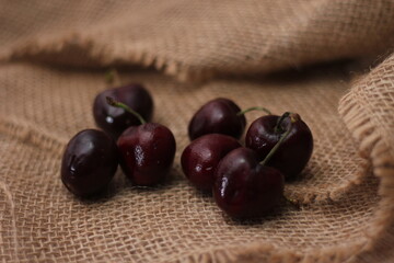 purple cherries placed on a cloth sack