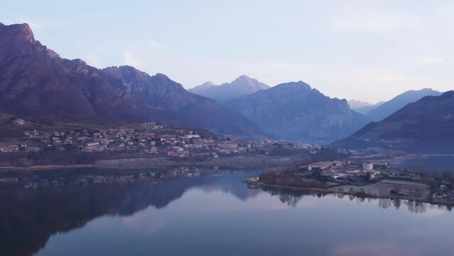 Lake Annone and Civate town seen from a drone before the sunrise. Beautiful mountains in the background.
