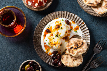 Cilbir or Turkish Eggs. mezze: poached eggs topped over herbed greek yogurt, then drizzled with hot spiced paprika olive oil. Traditional Turkish breakfast with rahat