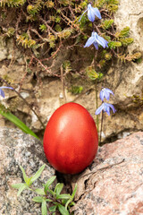 Home-made red Easter egg between the stones