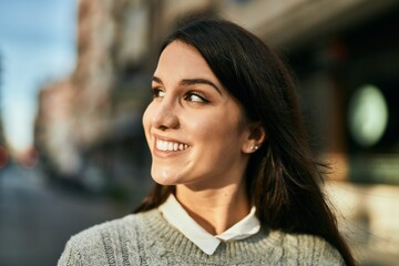 Young hispanic woman smiling happy standing at the city.