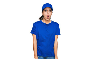 Young hispanic girl wearing delivery courier uniform afraid and shocked with surprise expression, fear and excited face.