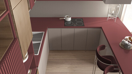 Cozy red and wooden kitchen in modern apartment, table, velvet armchairs. Sink, induction hob with...