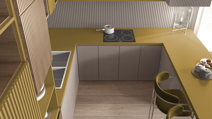 Cozy yellow and wooden kitchen in modern apartment, table, velvet armchairs. Sink, induction hob with pot, breakfast with cookies. Glass table lamp. Top view, above, interior design