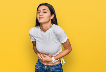 Young hispanic girl wearing casual white t shirt with hand on stomach because indigestion, painful illness feeling unwell. ache concept.